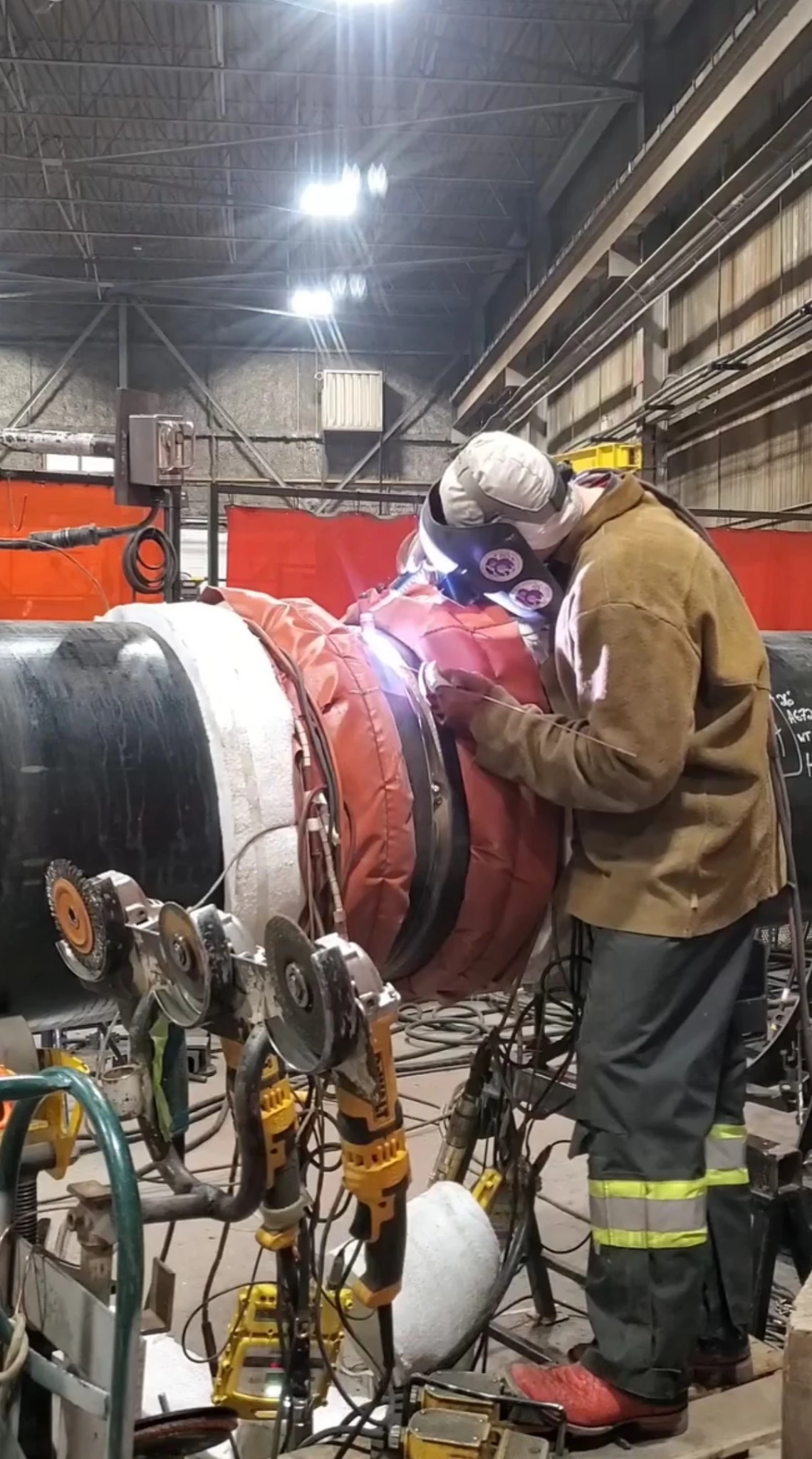 Travis Field roll welding a large chrome-moly pipe joint in a fabrication shop